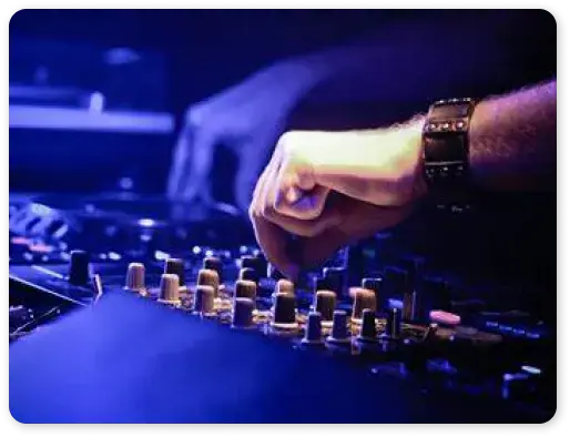 DJ adjusting the knobs on a mixing console